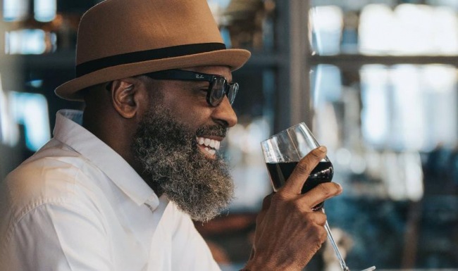 man sitting with a glass of wine in his hand